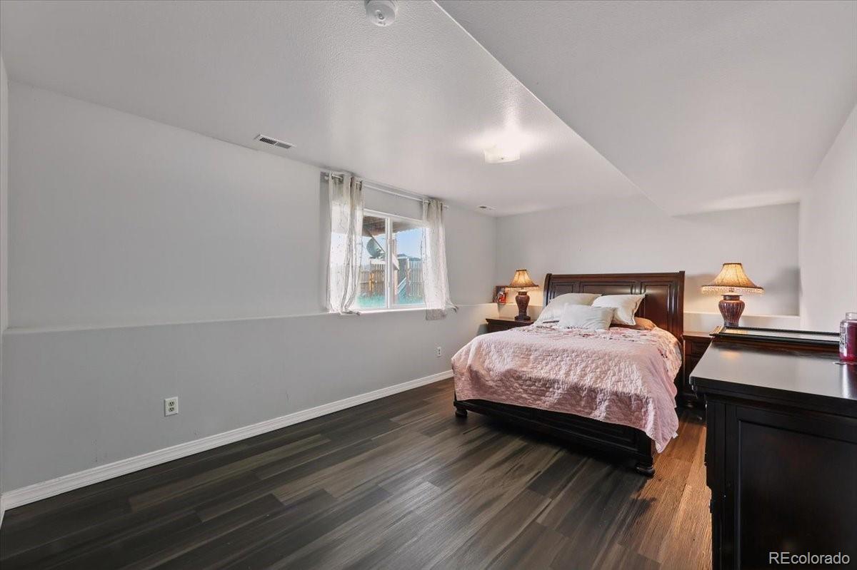 17435 Wagon Train Loop Peyton, CO 80831 - Photo 15 of 40 a bedroom with a bed and wooden floor