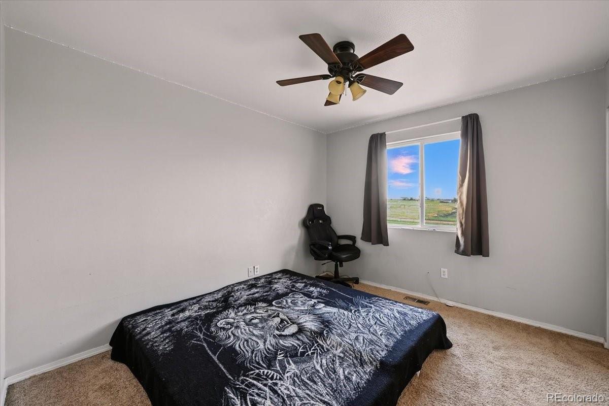 17435 Wagon Train Loop Peyton, CO 80831 - Photo 25 of 40 a bed sitting in a bedroom next to a window