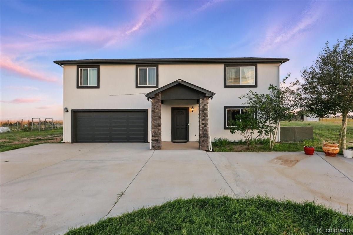 17435 Wagon Train Loop Peyton, CO 80831 - Photo 3 of 40 a front view of a house with a yard and garage