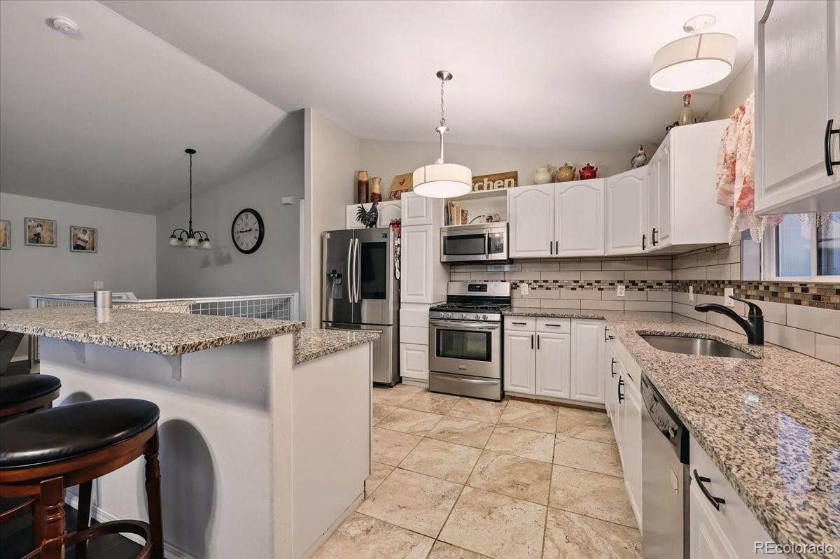 17435 Wagon Train Loop Peyton, CO 80831 - Photo 7 of 40 a kitchen with a stove a sink and a refrigerator