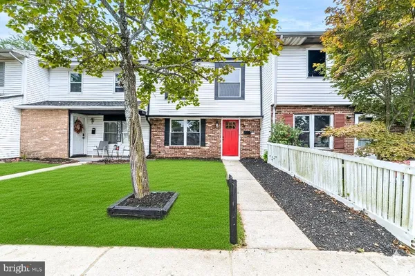 a front view of a house with a yard and potted plants