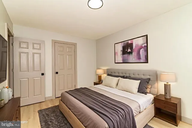 a bedroom with a bed and a painting on the wall