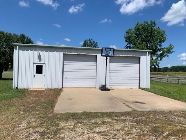 2251 Old Stage Road Adamsville, TN 38310 - Photo 3 of 17 a front view of a house with a yard and garage