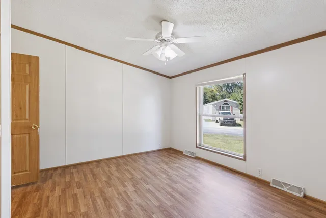 a view of an empty room with wooden floor