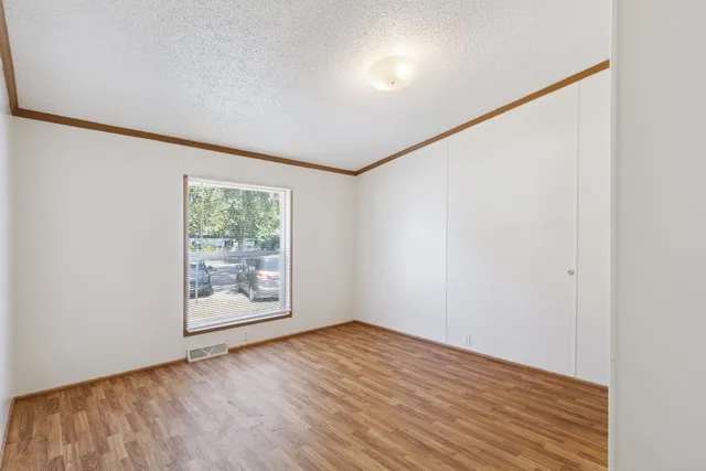 an empty room with wooden floor and closet