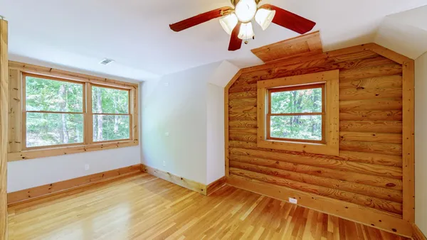 a big room with wooden floor and windows