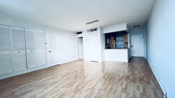 a view of a room with wooden floor and white walls