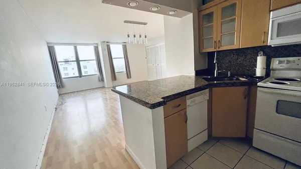 a kitchen with granite countertop a sink stove and cabinets