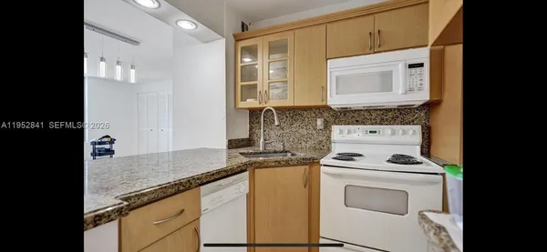 a kitchen with granite countertop cabinets stainless steel appliances and a sink