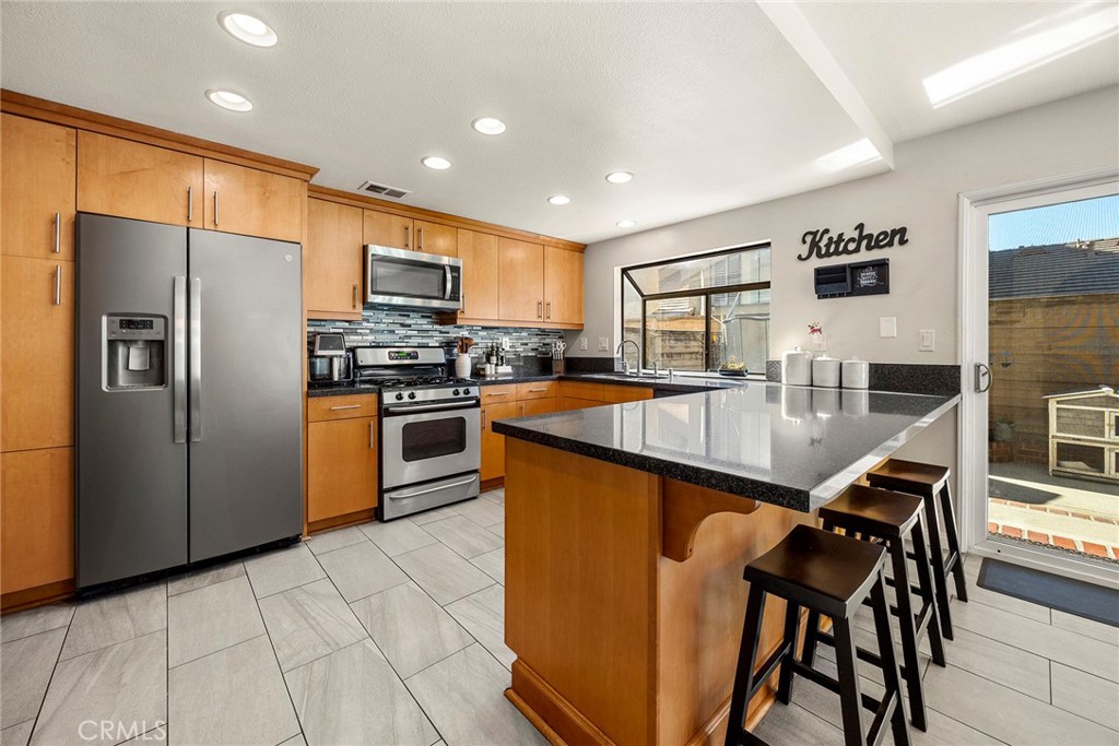 2027 Cobblefield Way Glendora, CA 91740 - Photo 11 of 34 a kitchen with stainless steel appliances granite countertop a stove refrigerator and a sink