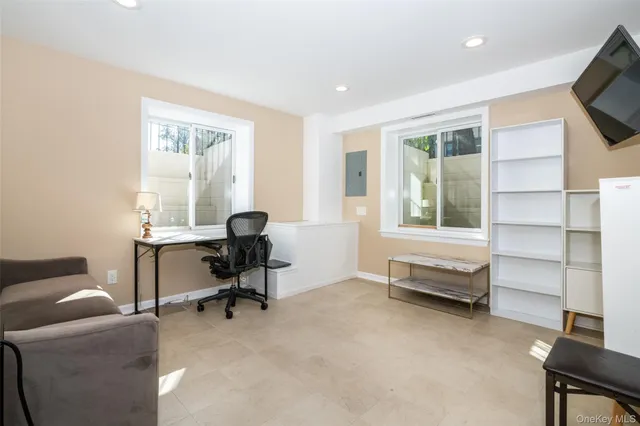 a view of a workspace with furniture and a window