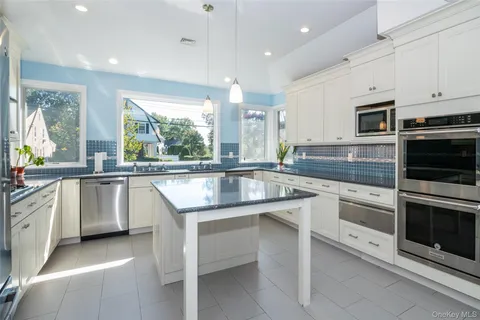 a kitchen with granite countertop a sink stainless steel appliances and cabinets
