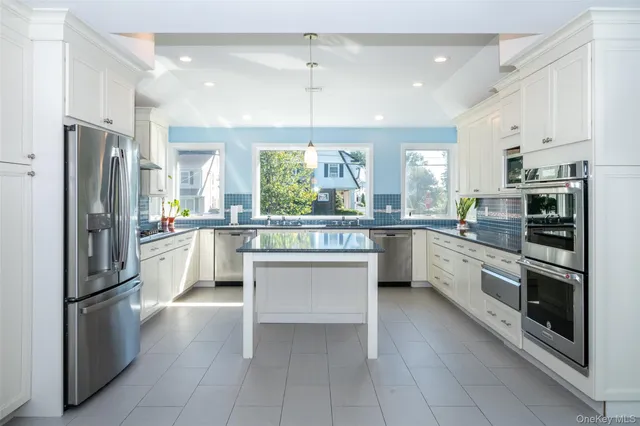 a kitchen with stainless steel appliances a refrigerator sink and cabinets