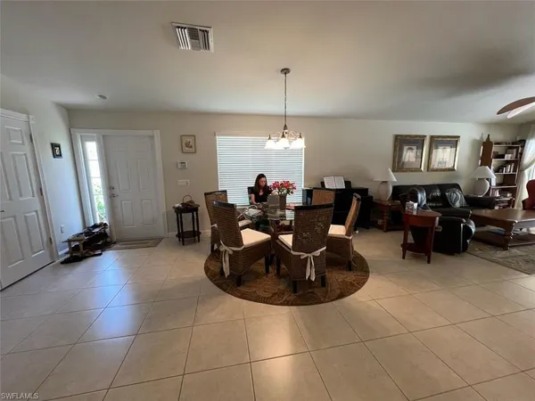 a living room with couches a computer and a window