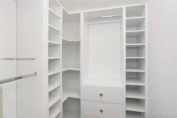 a view of walk in closet with empty racks