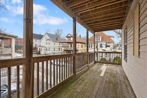 a view of a porch with wooden floor next to a yard