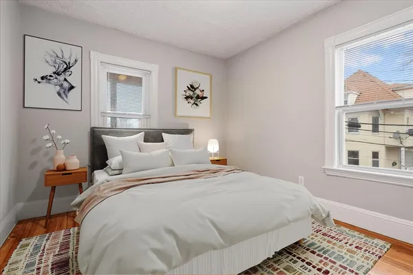 a bedroom with bed and a painting on the wall