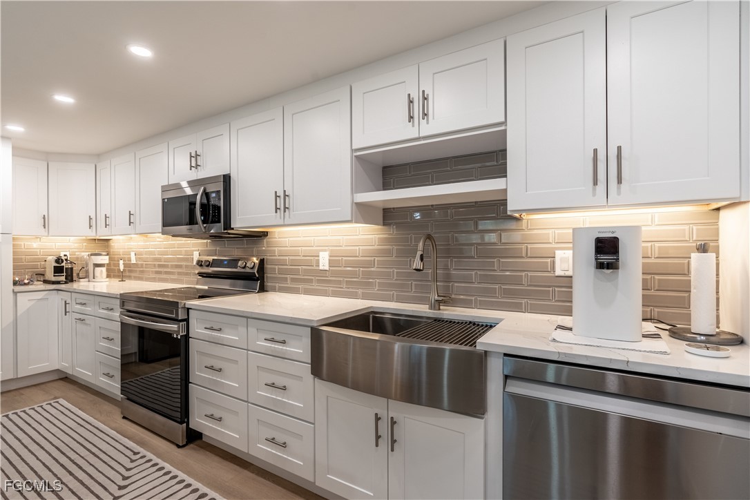 503 Broad Avenue South, Unit 503 Naples, FL 34102 - Photo 11 of 20 a kitchen with stainless steel appliances granite countertop a sink stove and cabinets