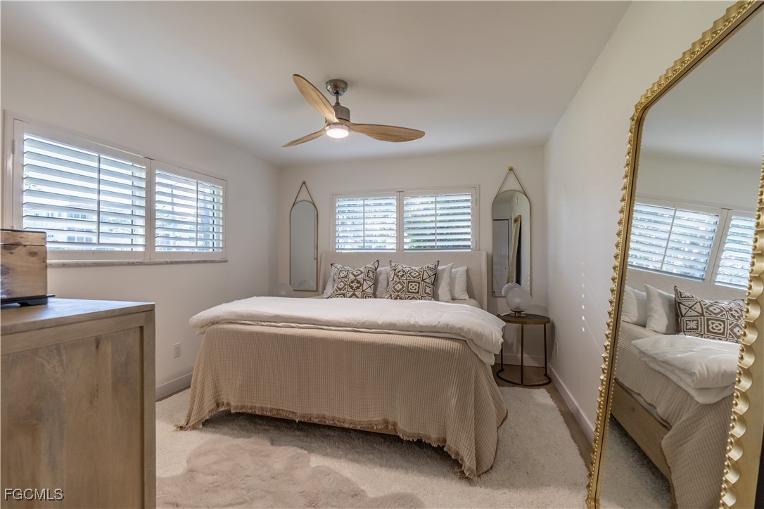 503 Broad Avenue South, Unit 503 Naples, FL 34102 - Photo 17 of 20 a bedroom with a bed and a chandelier