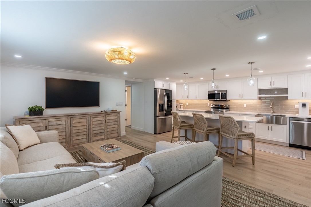503 Broad Avenue South, Unit 503 Naples, FL 34102 - Photo 5 of 20 a living room with furniture and a flat screen tv
