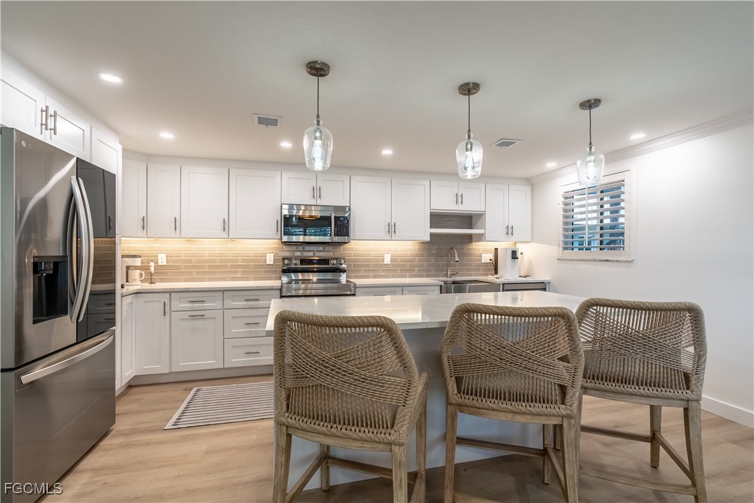 503 Broad Avenue South, Unit 503 Naples, FL 34102 - Photo 8 of 20 a kitchen with granite countertop cabinets stainless steel appliances and a dining table