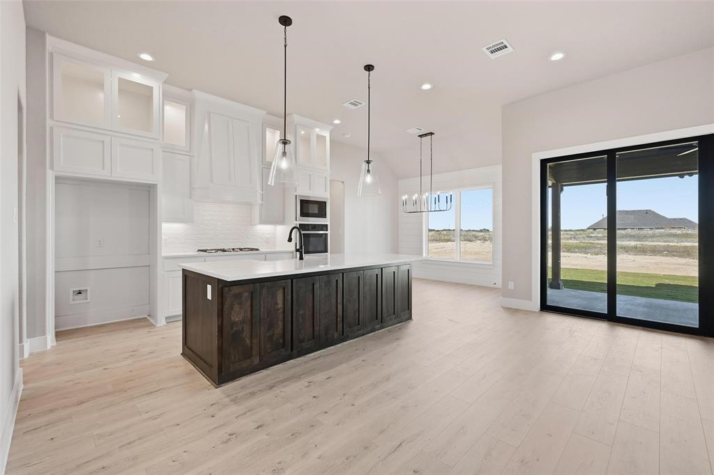 108 Rocky Top Azle, TX 76020 - Photo 10 of 40 a kitchen with stainless steel appliances kitchen island wooden cabinets and white appliances