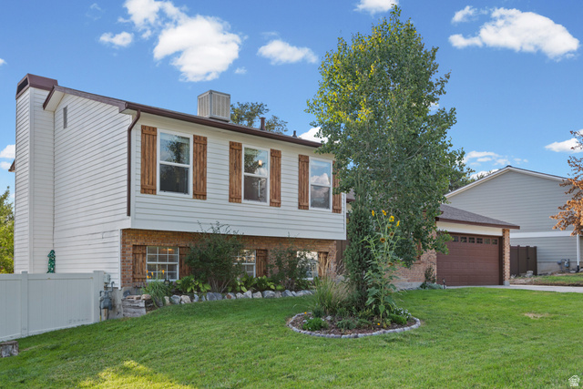Two-story colonial with brick and vinyl siding exterior, featuring bay windows with wood-finish frames on the main level