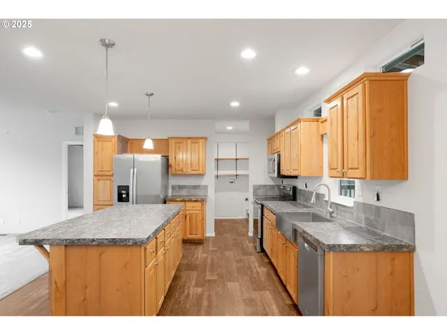 a kitchen with stainless steel appliances granite countertop a sink stove and cabinets
