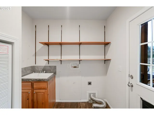 a kitchen with stainless steel appliances granite countertop a sink a stove and a wooden floors