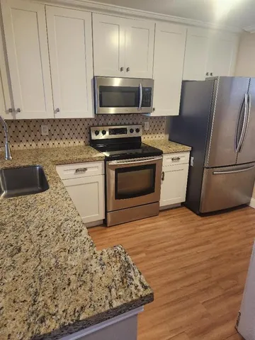 a kitchen with stainless steel appliances granite countertop a stove a sink and a refrigerator