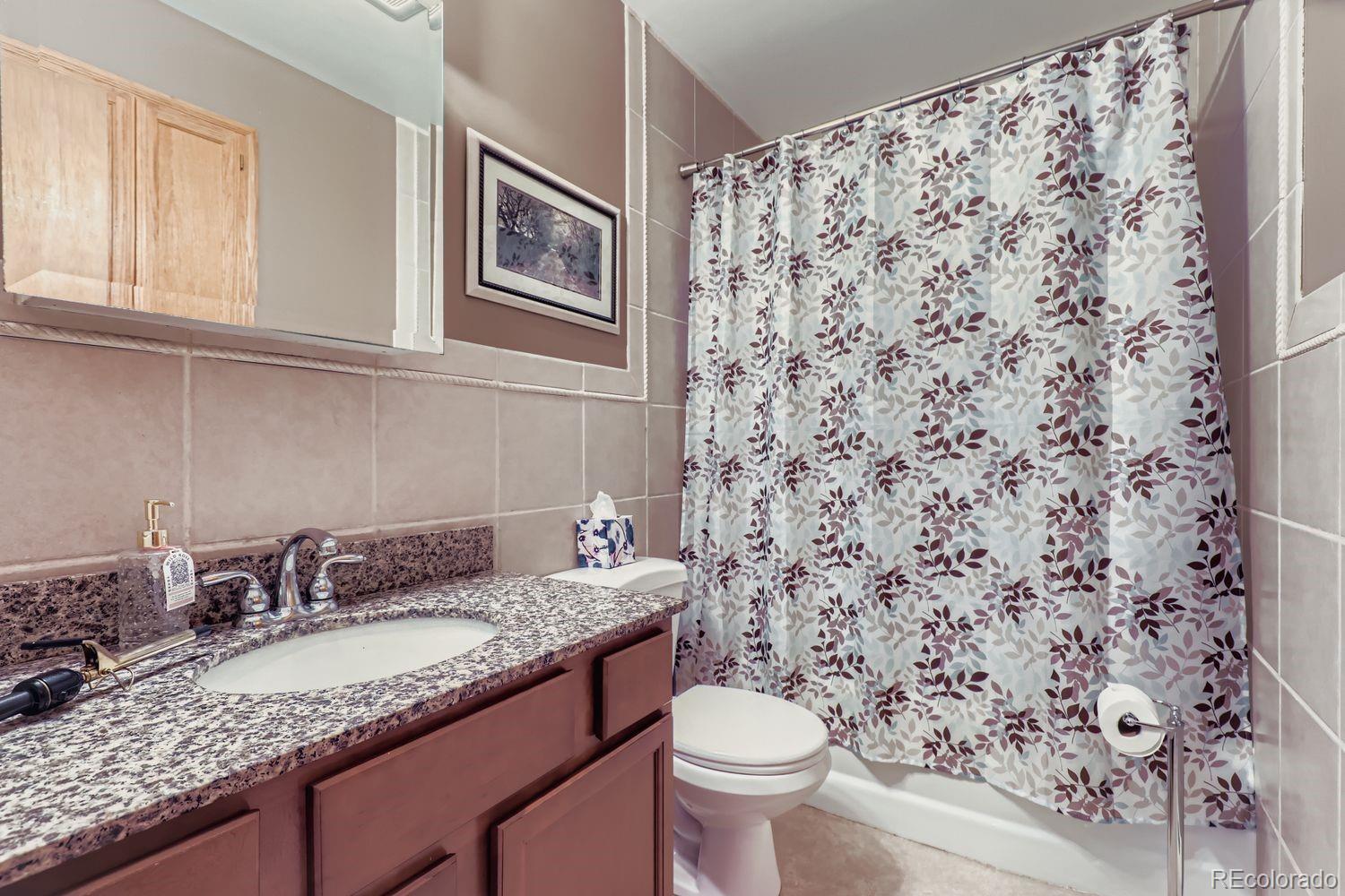 5441 East 67th Place Commerce City, CO 80022 - Photo 13 of 19 a bathroom with a granite countertop sink and a toilet