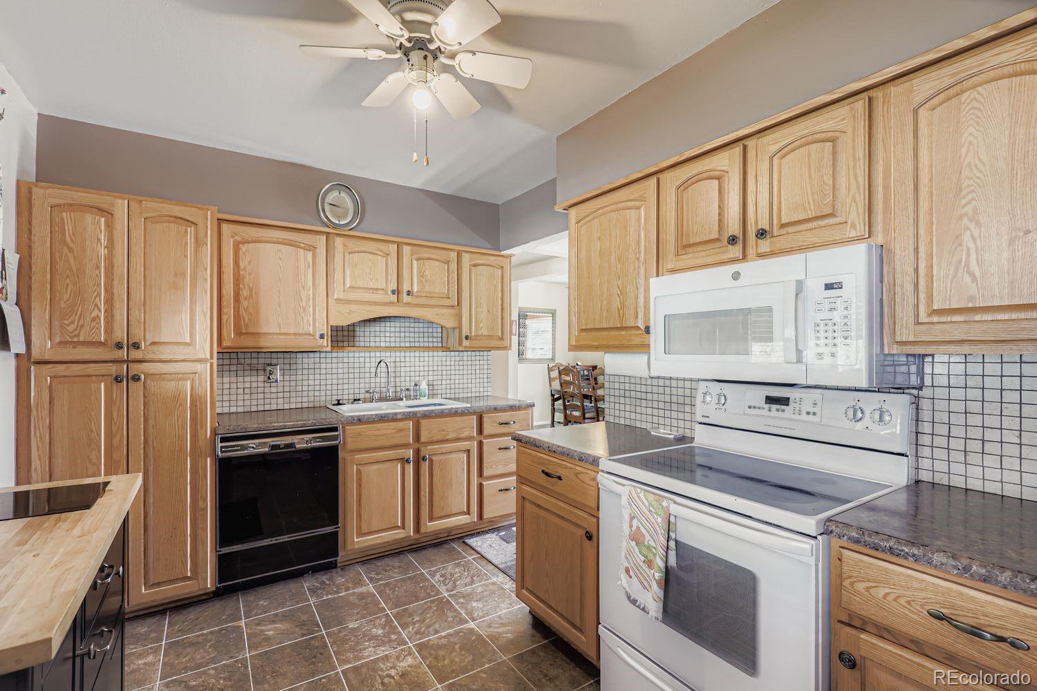 5441 East 67th Place Commerce City, CO 80022 - Photo 9 of 19 a kitchen with stainless steel appliances granite countertop a stove sink and cabinets