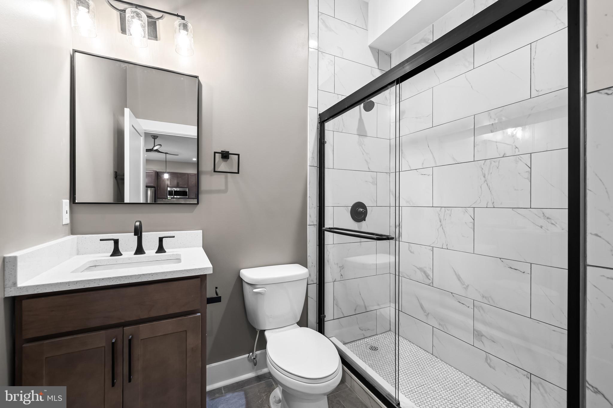 400 South Conkling Street, Unit 2 Baltimore, MD 21224 - Photo 16 of 17 a bathroom with a toilet sink vanity and mirror