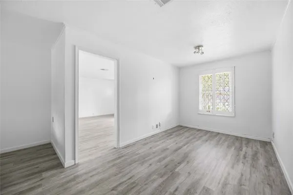 an empty room with wooden floor and window