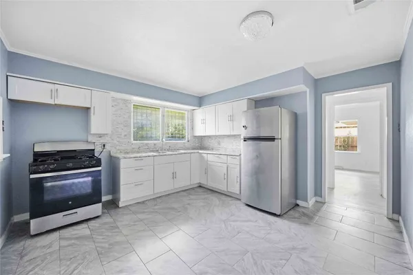 a kitchen with white cabinets and appliances