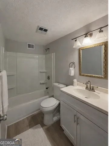 a bathroom with a sink toilet a mirror and shower