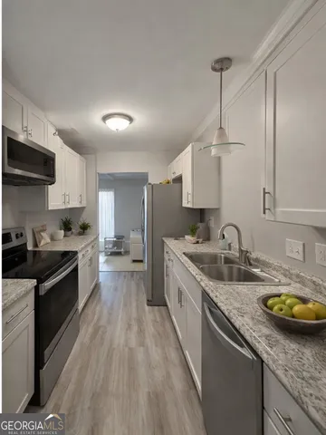 a large kitchen with a lot of counter space and wooden floor