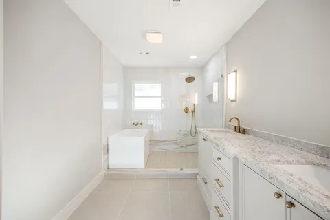 a bathroom with a double vanity sink mirror and toilet