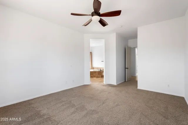 a view of an empty room and a ceiling fan