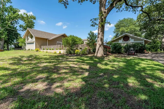 a front view of a house with a garden and trees