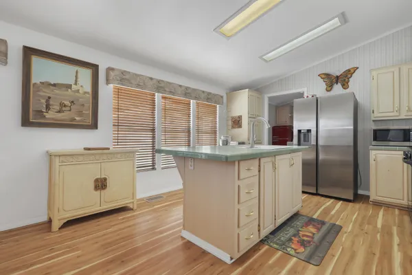 a kitchen with stainless steel appliances granite countertop a refrigerator a stove and a wooden floors