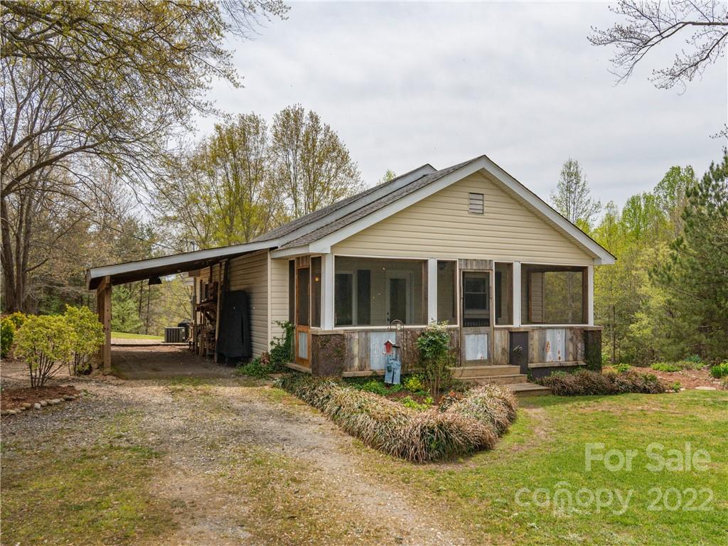 4467 Big Level Road Mill Spring, NC 28756 - Photo 15 of 33 a front view of a house with a yard and potted plants
