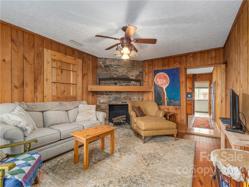 4467 Big Level Road Mill Spring, NC 28756 - Photo 4 of 33 a living room with furniture a fireplace and a flat screen tv