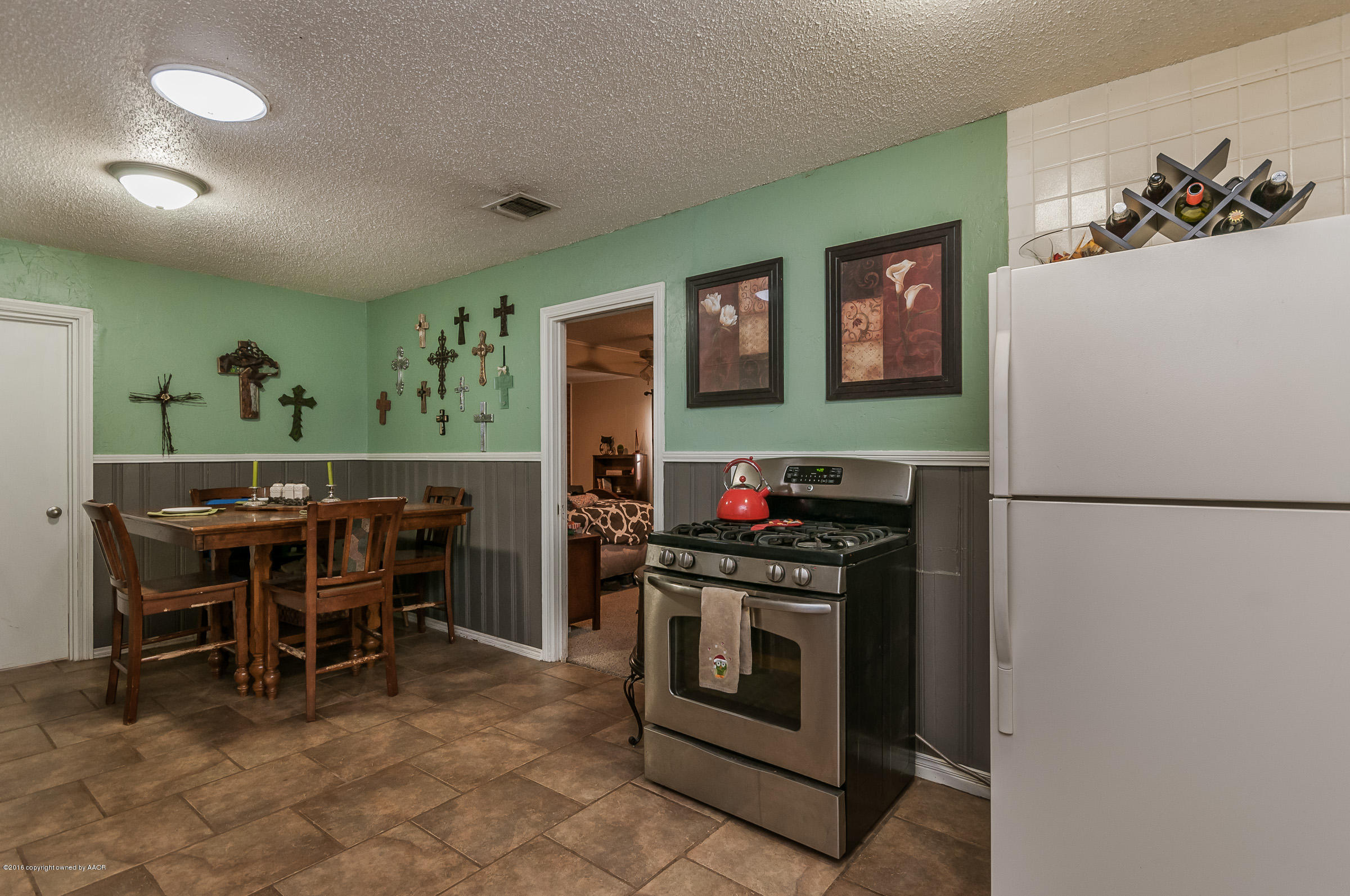3807 Gables Street Amarillo, TX 79110 - Photo 8 of 16 a kitchen with stainless steel appliances a stove a refrigerator and a dining table