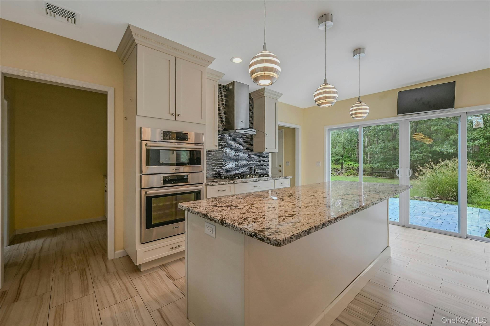 144 S Path Calverton, NY 11933 - Photo 12 of 19 a kitchen with stainless steel appliances granite countertop a stove oven and a wooden floor
