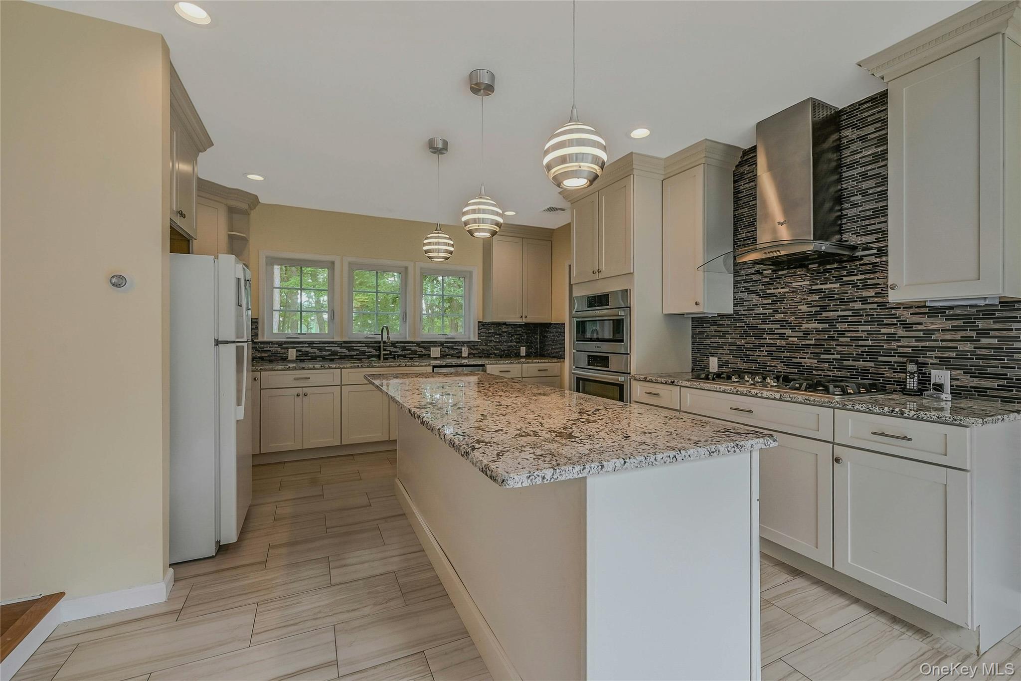 144 S Path Calverton, NY 11933 - Photo 13 of 19 a kitchen with stainless steel appliances granite countertop a sink and cabinets