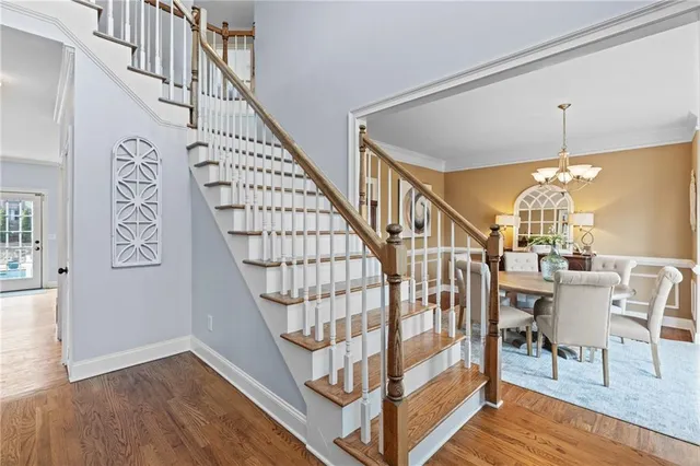 a living room with stainless steel appliances furniture a chandelier and a view of kitchen