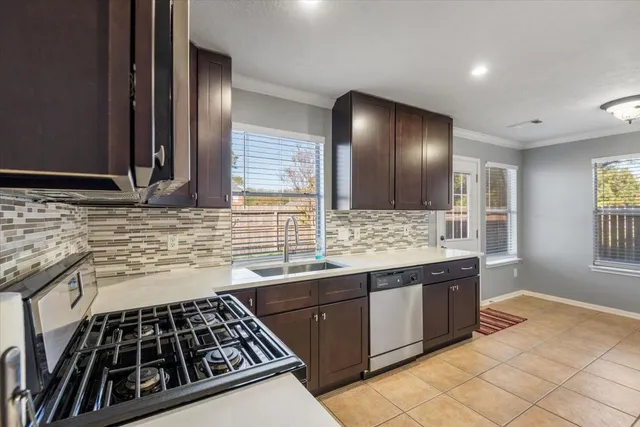 a kitchen with stainless steel appliances granite countertop wooden cabinets a sink and a stove