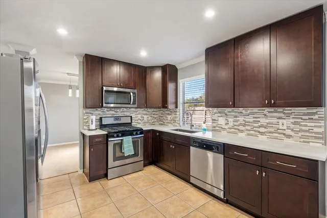 a modern kitchen with stainless steel appliances granite countertop a refrigerator and a stove top oven