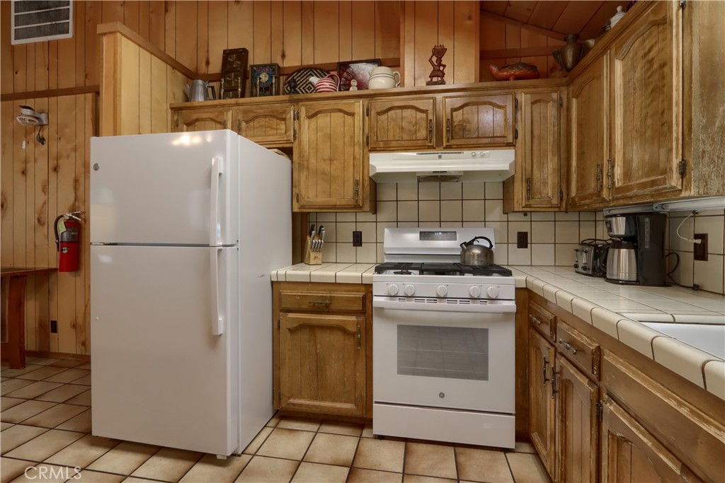 8041 Chilnualna Falls Road Wawona, CA 95389 - Photo 11 of 46 a kitchen with stainless steel appliances granite countertop a refrigerator and a stove